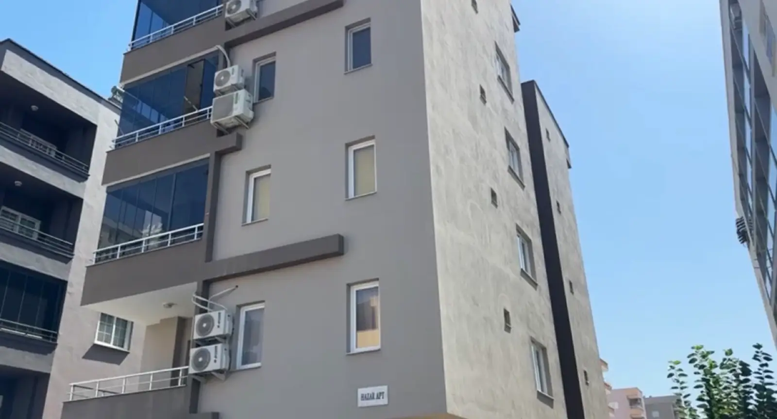 Sokaktan görünen bina, duvarında HazarApt tabelası