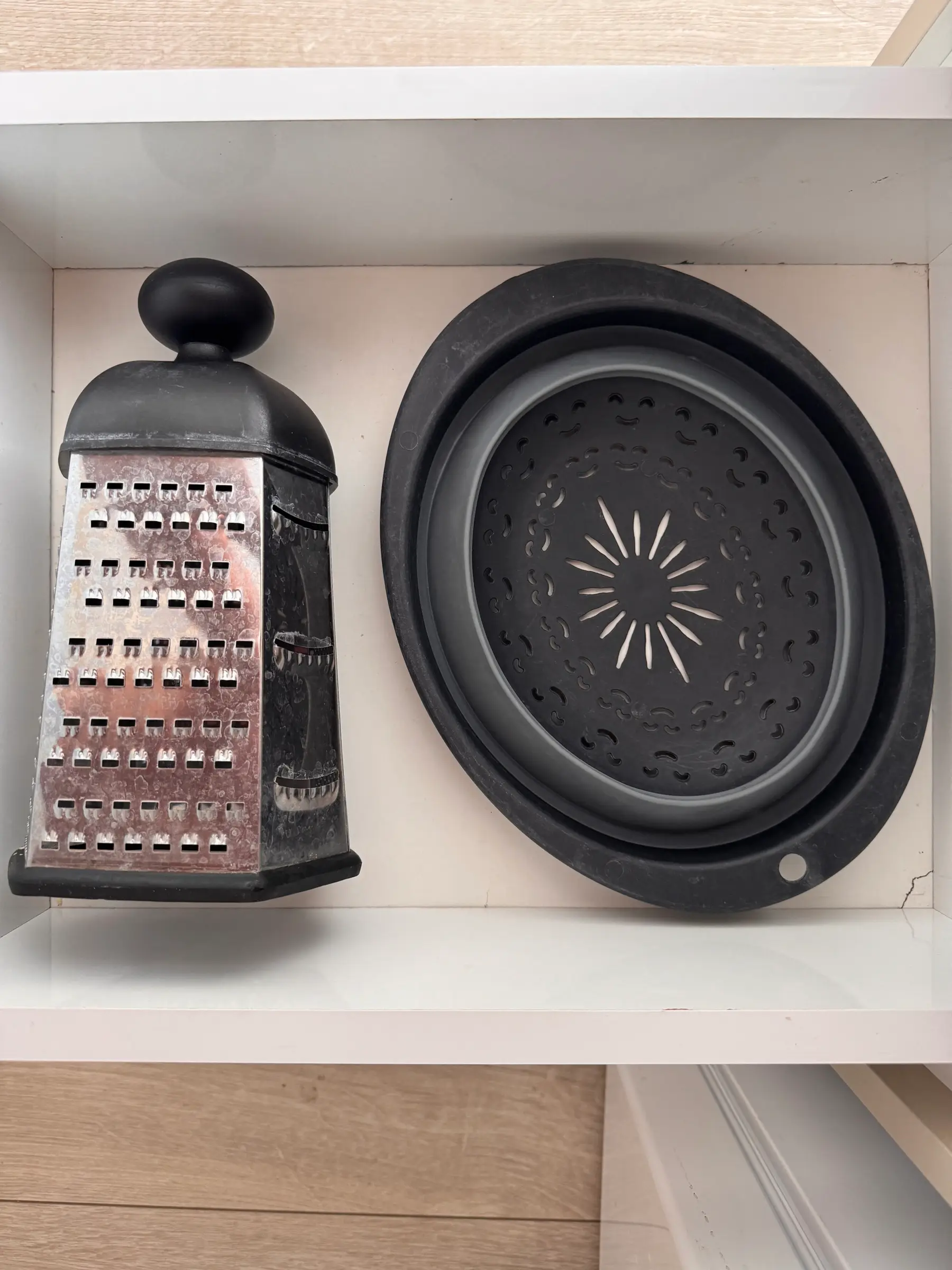 Pan and grater in the kitchen cupboard