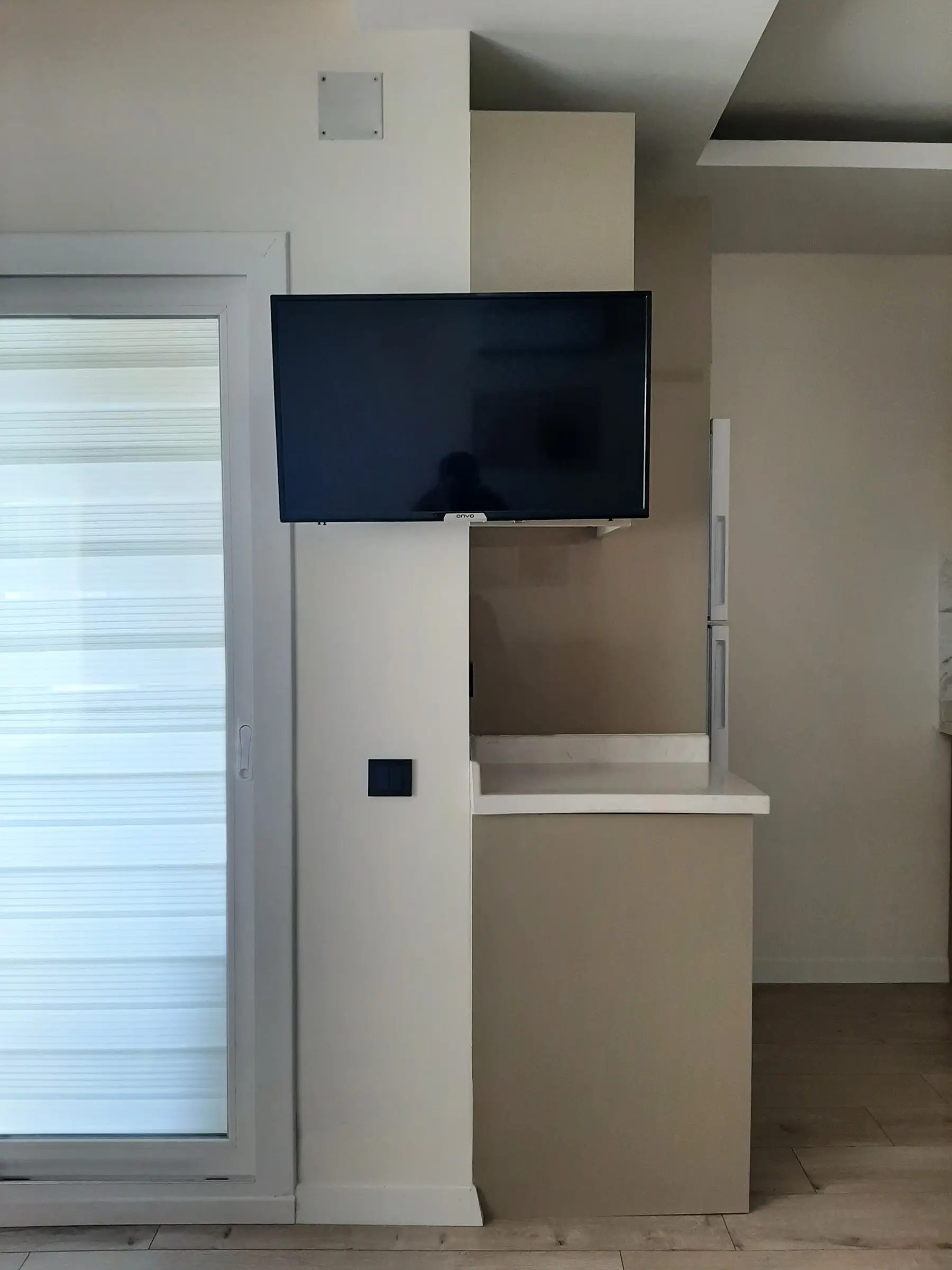 Smart TV mounted on the partition between kitchen and living room