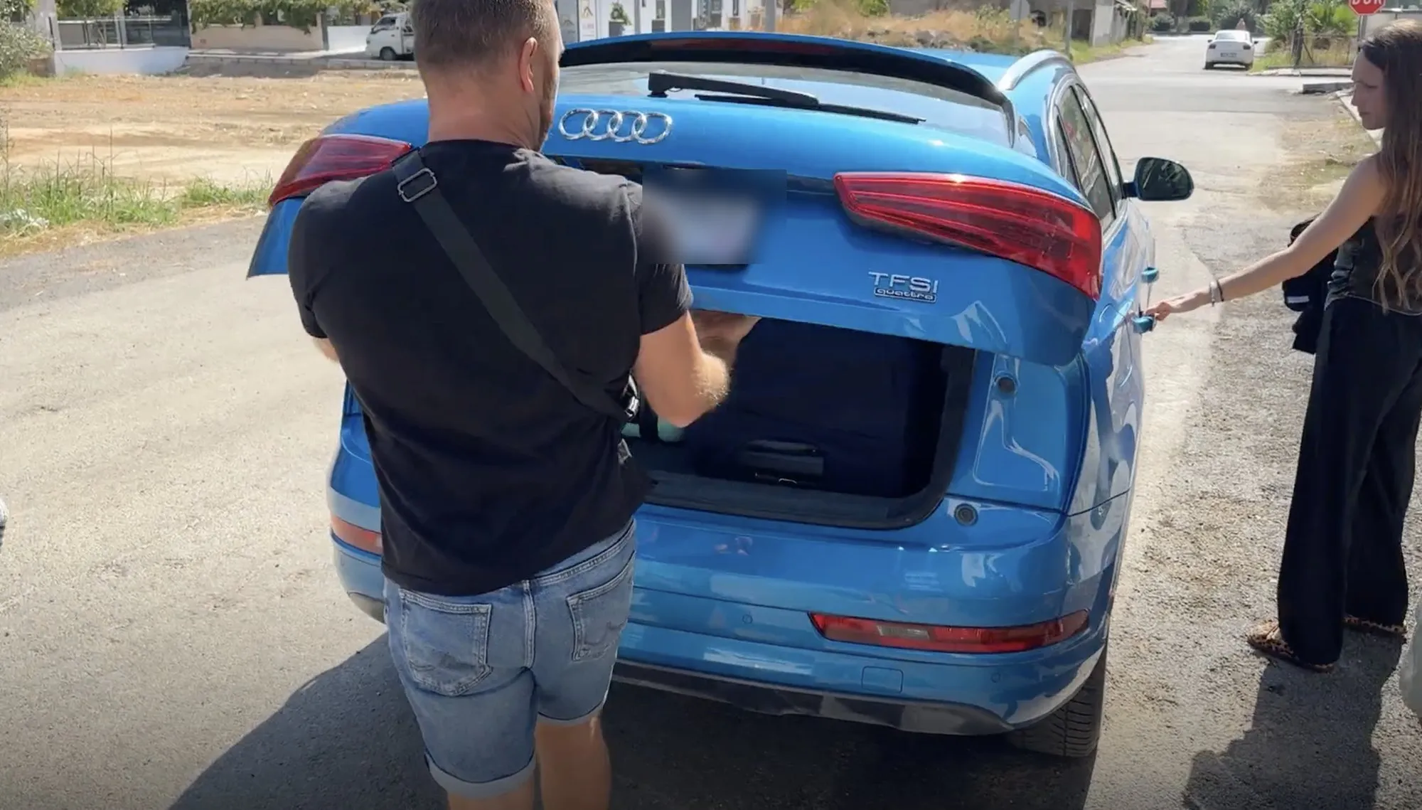 Luggage being loaded into a car outside the building