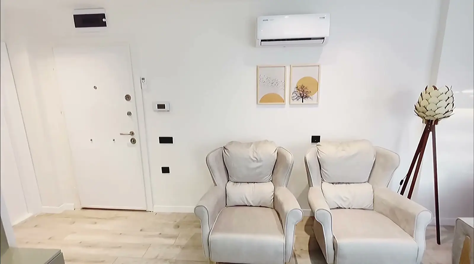 Opening frame of the apartment tour: the entrance, armchairs and floor lamp